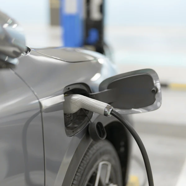 Ein Elektroauto wird an einer Ladestation mit einem Ladekabel aufgeladen.